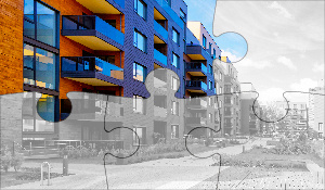 Puzzle of a modern apartment building with two pieces in color, representing the next insight in the multifamily real estate insurance series
